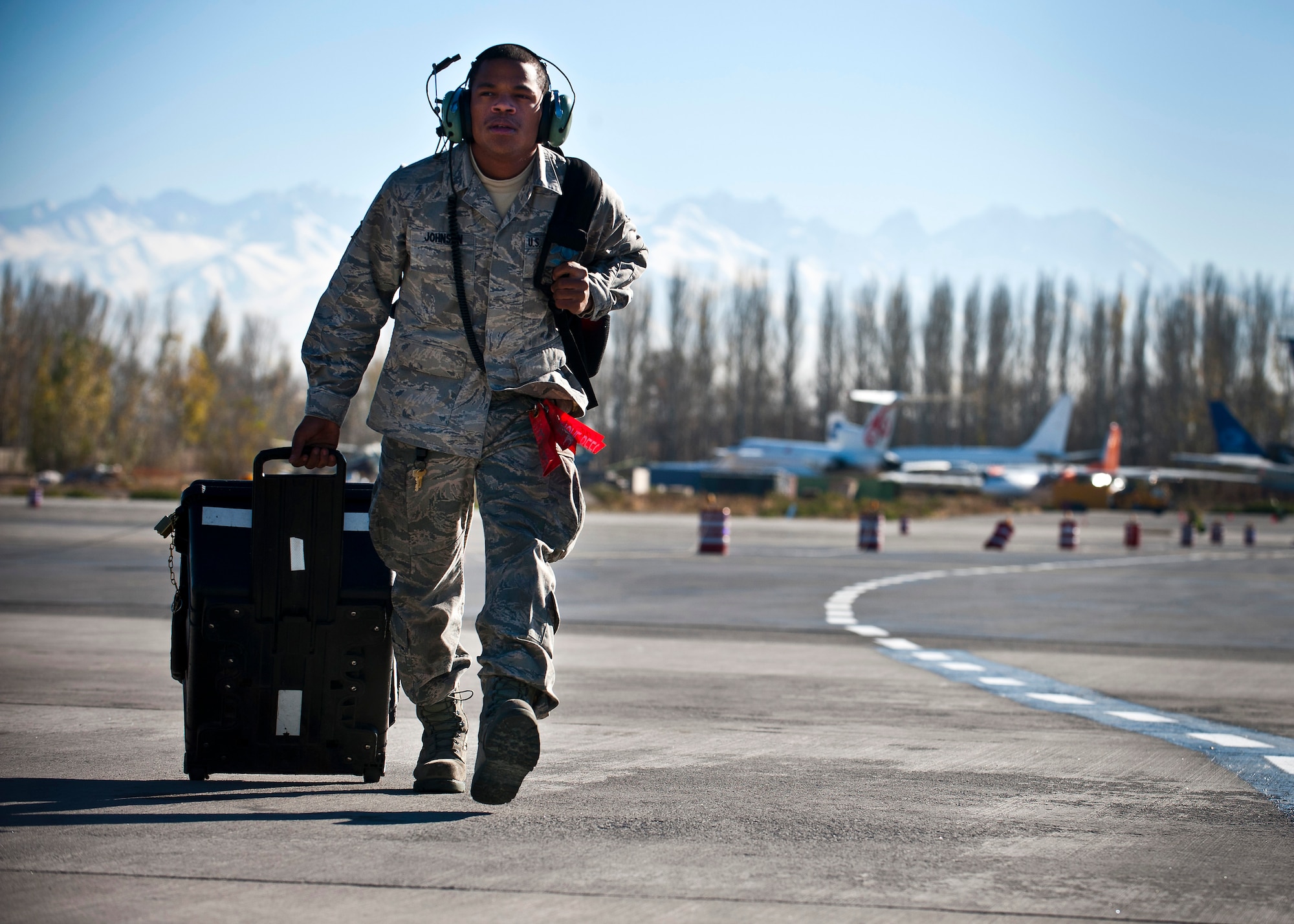 Airman 1st Class Monquavious Johnson hauls his equipment across the flight line at the Transit Center at Manas, Kyrgyzstan, Nov. 8, 2012. Crew chiefs are responsible for the maintenance of the aircraft and support equipment to keep them operational. Johnson is a 376th Expeditionary Aircraft Maintenance Squadron crew chief who is deployed from MacDill Air Force Base, Fla., and a native of Atlanta. (U.S. Air Force photo/Senior Airman Brett Clashman)