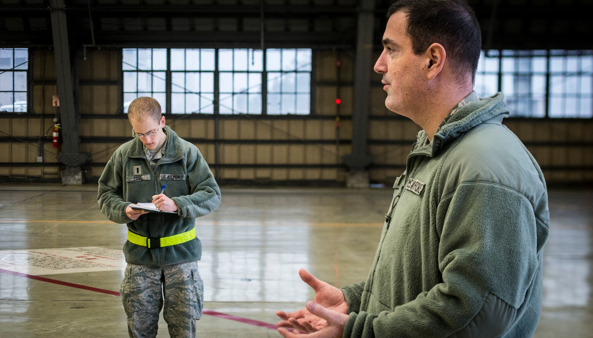 YOKOTA AIR BASE, Japan -- In a simulated press conference, 1st Lt. Christopher Love, left, 374th Airlift Wing acting chief of public affairs, takes notes while Col. Mark August, 374 AW commander, talks to simulated reporters during an operational readiness exercise at Yokota Air Base, Japan, Nov. 6, 2012. The exercise scenario not only tested August's ability to answer tough questions, but also the public affairs office's ability to prepare him with all the information he would need to answer those questions confidently. (U.S. Air Force photo by Tech. Sgt. Samuel Morse)