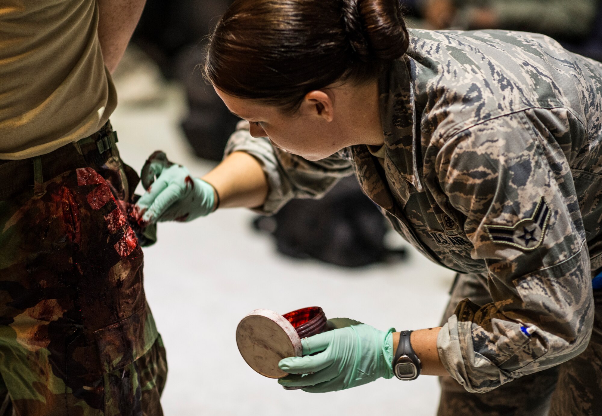 YOKOTA AIR BASE, Japan -- Airman 1st Class Kiley Adams, 374th Medical Surgical Squadron, applies fake blood to a simulated injury in preparation for an exercise at Yokota Air Base, Japan, Nov. 6, 2012. Yokota's exercise evaluation team created a natural disaster scenario within a larger weeklong operational readiness exercise. (U.S. Air Force photo by Tech. Sgt. Samuel Morse)