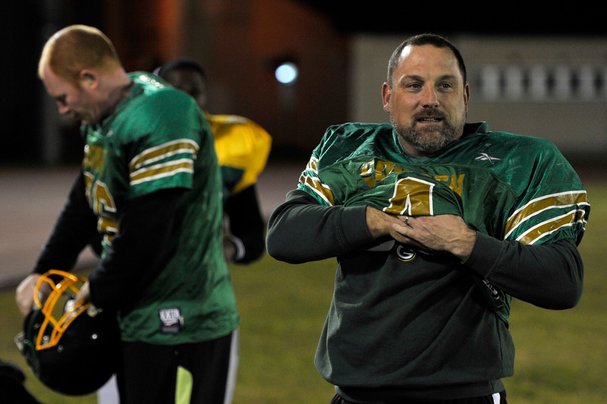 Paul Finco, Edgren High School football assistant coach, puts on shoulder pads during the Eagles practice at Misawa Air Base, Japan, Nov. 7, 2012. Edgren had five of their coaches put on pads to simulate having bigger players on the opposite side of the ball to mimic what they will face against the Zama Trojans in the Division II championship game. (U.S. Air Force photo by Airman 1st Class Zachary Kee)
