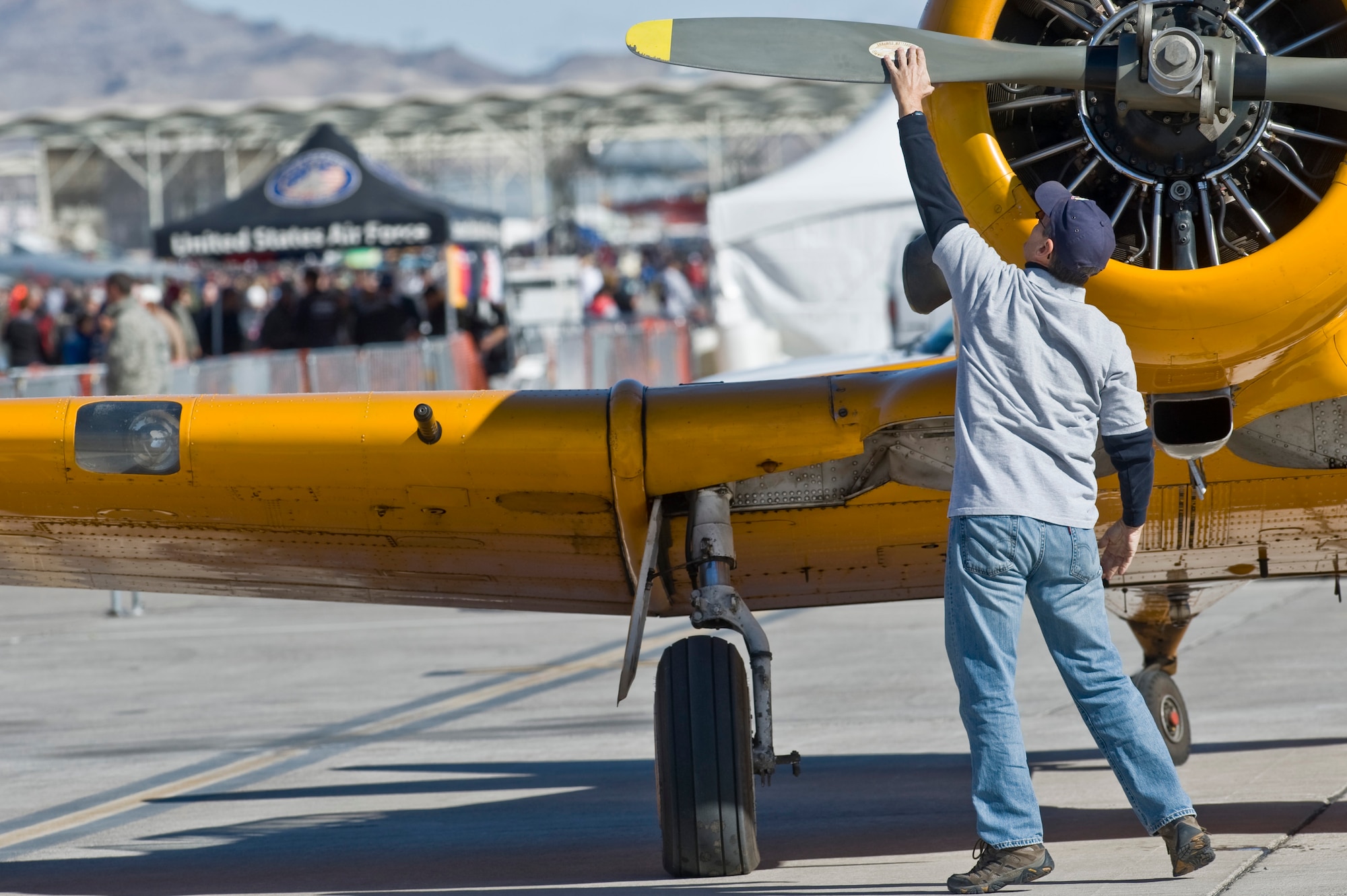Retired U.S. Air Force Col. Robert Hertbert, turns the propeller of an AT-6 prior to start up during Aviation Nation Nov. 10,2012, at Nellis Air Force Base, Nev. The AT-6 is taking part in a Korean War Conflict demonstration. (U.S. Air Force Photo By Senior Airman Daniel Hughes) 