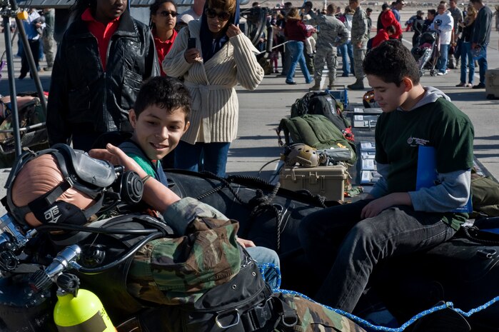 Junior Funes and Adrian Pedroza from the Innovations International Charter School of Nevada sit in a skiff at the 58th Rescue Squadron's booth at Aviation Nation Nov. 8, 2012, at Nellis Air Force Base, Nev. The Flightline Frenzy gave students from local schools the opportunity to view static displays and aerial demonstrations. (U.S. Air Force Photo by Senior Airman Daniel Hughes) 