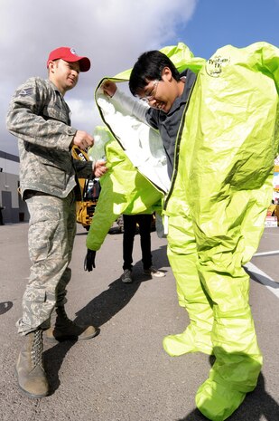 U.S. Air Force Staff Sgt. Ian Zerby, 820th RED HORSE Squadron emergency management, helps Ricardo Arzadon, Legacy High School senior, into a level-A hazardous material suit during Construction Career Day Nov. 09, 2012, at the Las Vegas Motor Speedway, Nev. Level A suits provide the highest level of protection against vapors, gases, mists, and particles. (U.S. Air Force photo by Staff Sgt. William P. Coleman)
  

