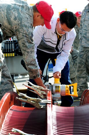 Airman 1st Class Clayton Crocker, 820th RED HORSE Squadron structural journeyman, shows Gairo Florez, Bonanza High School freshman, how to piece together K-spans using a seamer during Construction Career Day Nov. 09, 2012, at the Las Vegas Motor Speedway, Nev. The 820th RED HORSE Squadron showcased a variety of fields including: pavements and equipment, emergency management and demolition to inform high school students who are considering a career in construction.  (U.S. Air Force photo by Staff Sgt. William P. Coleman)
  

