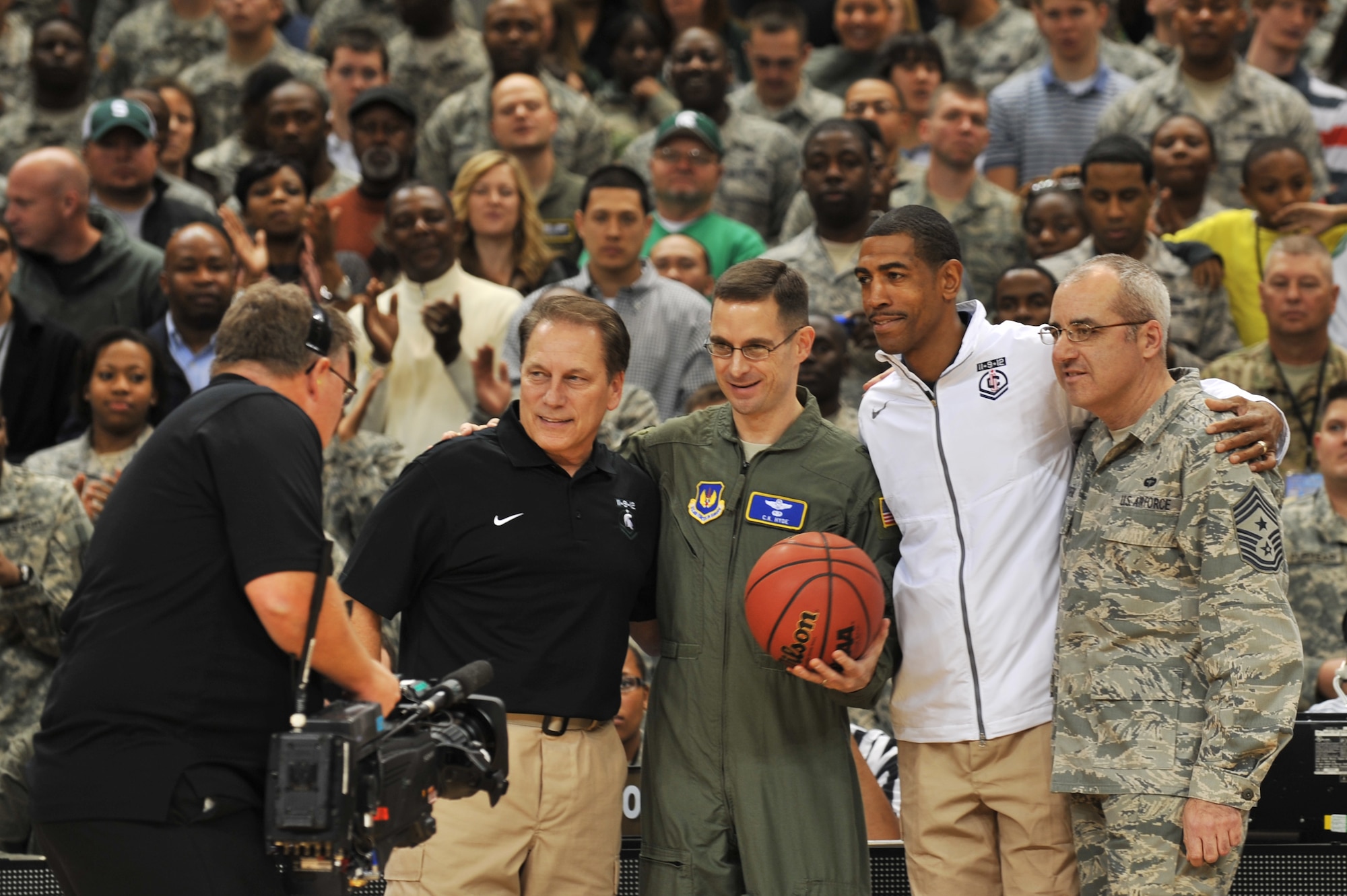 Brig. Gen. C.K. Hyde, 86th Airlift Wing commander, along with Chief Master Sgt. James Morris, 86th Airlift Wing command chief, presents head coaches Kevin Ollie, University of Connecticut, and Tom Izzo, Michigan State, with the game ball during the 2012 Armed Forces Classic on Ramstein Air Base, Germany, Nov. 10, 2012. The match-up between MSU and UCONN is part of ESPN's Veteran's week initiative to honor the men and women who have served and are still serving in the U.S. military. (U.S. Air Force photo/Senior Airman Caitlin O’Neil-McKeown)