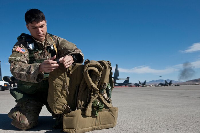 Staff Sgt. Shane Lahaie, 820th RED HORSE airborne member, prepares gear for a static-line jump during of the opening ceremony of Aviation Nation Nov. 10, 2012, at Nellis Air Force Base, Nev. Five members of the 820th RED HORSE Squadron participated in the jump mission. (U.S. Air Force photo by Staff Sgt. Christopher Hubenthal)