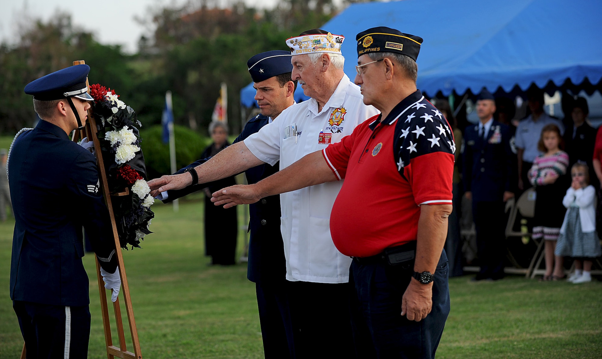 Don Allen, Okinawa American Legion commander, Dennis Provencher, Okinawa Veterans of Foreign Wars commander, and U.S. Air Force Brig. Gen. Matt Molloy, 18th Wing commander, place a hand on the Prisoners of War/Missing in Action Wreath as it is walked to the base of the flagpoles during the Veterans Day ceremony at the 18th Wing headquarters building on Kadena Air Base, Japan, Nov. 12, 2012. During the ceremony, members from each branch of service on Okinawa came together to recognize the sacrifices made by all U.S. veterans, past and present. (U.S. Air Force photo/Airman 1st Class Hailey R. Davis)