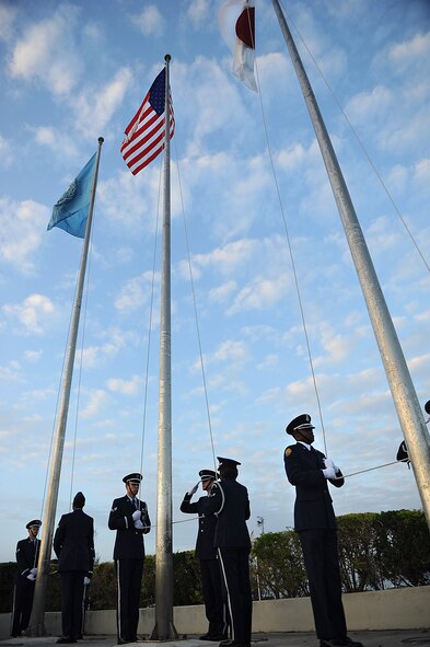 Members of the Kadena Honor Guard and Junior ROTC salute the NATO, American and Japanese flags after reveille is played during the Veterans Day ceremony at the 18th Wing headquarters building on Kadena Air Base, Japan, Nov. 12, 2012. Following the raising of the flag and the Japanese and American national anthems, a representative from each service recited their branch's creed and guest speakers shared their experiences with the crowd. (U.S. Air Force photo/Airman 1st Class Hailey R. Davis)