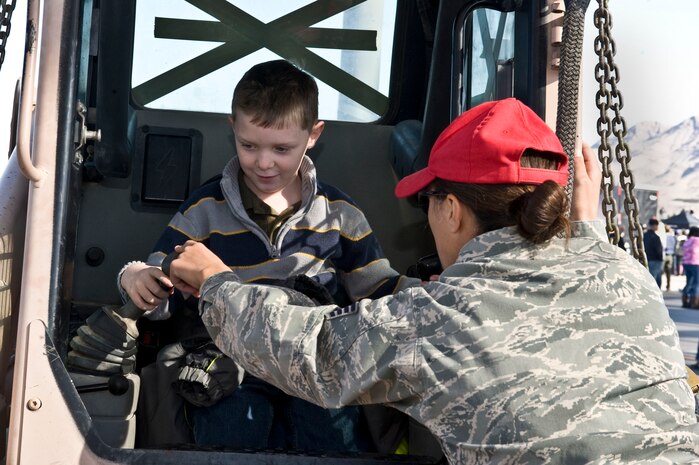 Staff Sgt. Christine Phillips, 820th RED HORSE Squadron engineering assistant, shows Dakota Ducharme how to operate a skidsteer during the annual Aviation Nation open house, Nov. 11, 2012, at Nellis Air Force Base, Nev. The 820th RED HORSE Squadron uses a skidsteer during sling load operations. (U.S. Air Force photo by Senior Airman Matthew Lancaster)