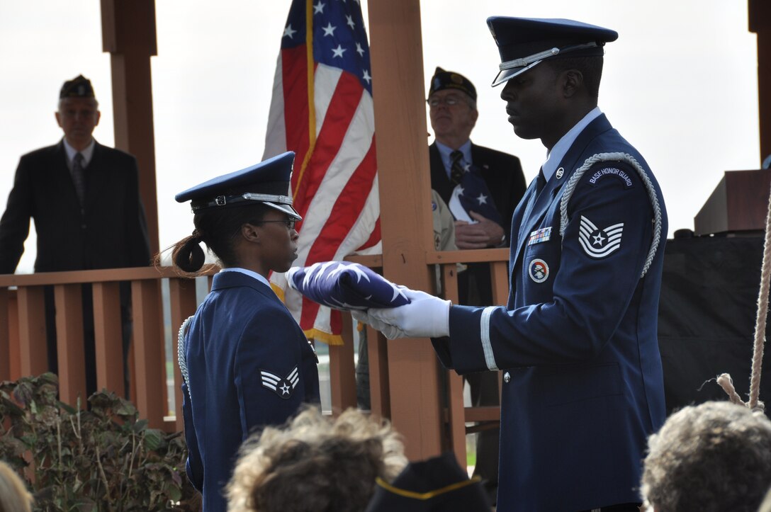 Tech. Sgt. Jermell Motley (right), Niagara Falls Air Base Honor Guard, presents the U.S. flag to fellow honor guard member Senior Airman Latosha Cain at the conclusion of a flag fold ceremony presented during a Veterans Day ceremony in the Town of Cambria, N.Y. November 11, 2012.  (U.S. Air Force photo by Master Sgt. Kevin Nichols)