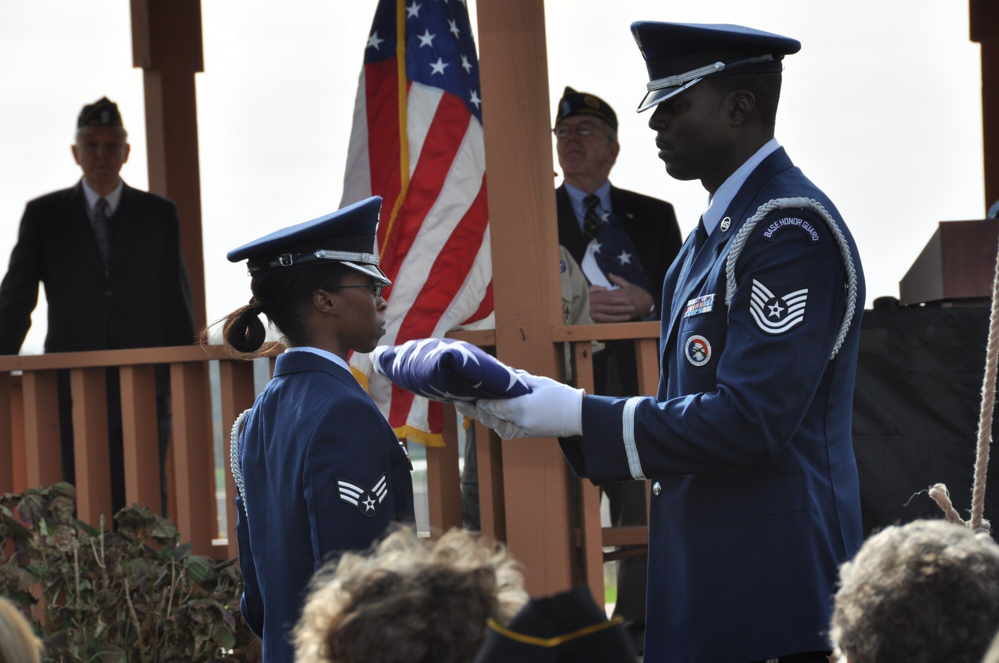 Tech. Sgt. Jermell Motley (right), Niagara Falls Air Base Honor Guard, presents the U.S. flag to fellow honor guard member Senior Airman Latosha Cain at the conclusion of a flag fold ceremony presented during a Veterans Day ceremony in the Town of Cambria, N.Y. November 11, 2012.  (U.S. Air Force photo by Master Sgt. Kevin Nichols)