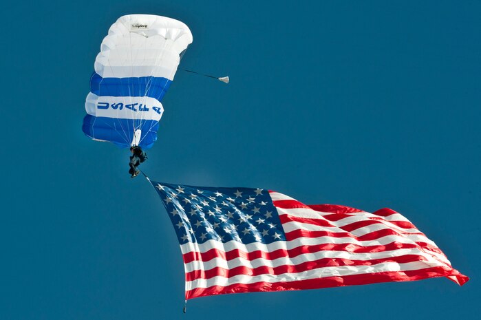 A United States Air Force Academy cadet from the Wings of Blue demonstration team displays the American flag during the Aviation Nation opening ceremony Nov. 11, 2012, at Nellis Air Force Base, Nev. Members of the Wings of Blue team serve primarily as instructors and jump masters for the Air Force basic free-fall course AM490. (U.S. Air Force photo by Airman 1st Class Jason Couillard)