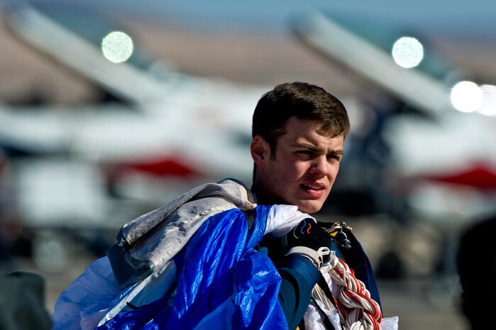 U.S. Air Force Academy Cadet 1st Class Jordan Loudenbac carries his parachute after completing a jump during Aviation Nation Nov.11, 2012, at Nellis Air Force Base, Nev. The Wings of Blue Demonstration Team participates in competitions at the collegiate level and performs at air shows worldwide. (U.S. Air Force Photo By Senior Airman Daniel Hughes)