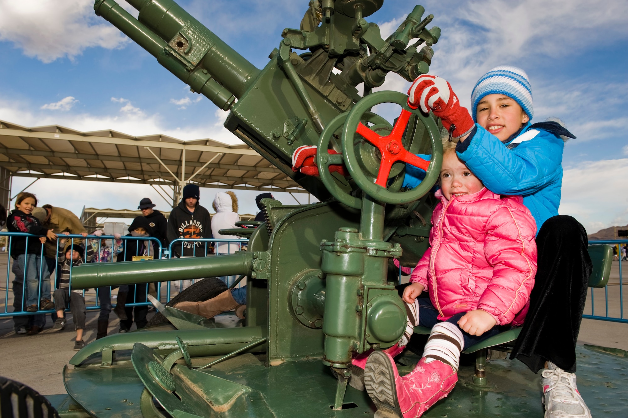 Cambria Davis and her little sister, Raia Davis, spin and move the barrel on a 37mm anti-aircraft artillery gun provided by the 547th Intelligence Squadron during Aviation Nation Nov.10, 2012, at Nellis Air Force Base, Nev. The 547th Intelligence Squadron provides comprehensive adversary tactics analysis, advanced unit intelligence training, and intelligence support for ongoing combat operations. (U.S. Air Force photo by Staff Sgt. William P. Coleman) 
  