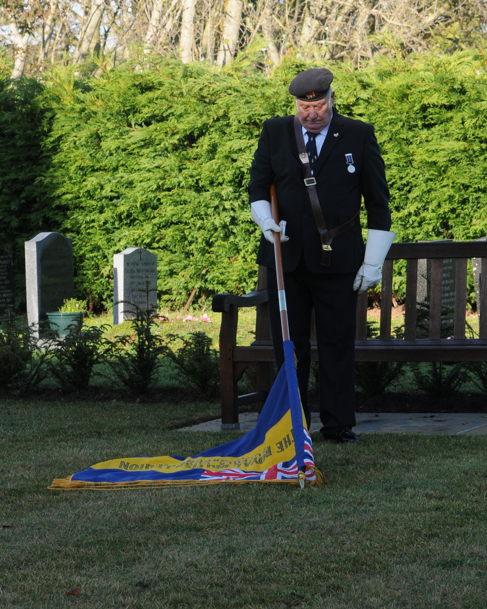 Harry Williams, Royal British Legion Lakenheath Chapter standard bearer, dips the flag as a sign of respect during a Remembrance Day wreath-laying ceremony Nov. 11, 2012, in Beck Row, England. Remembrance Day is held on Nov. 11 every year as a way to pay respect to military members who lost their lives. (U.S. Air Force Photo by Airman 1st Class Kelsey Waters/Released)