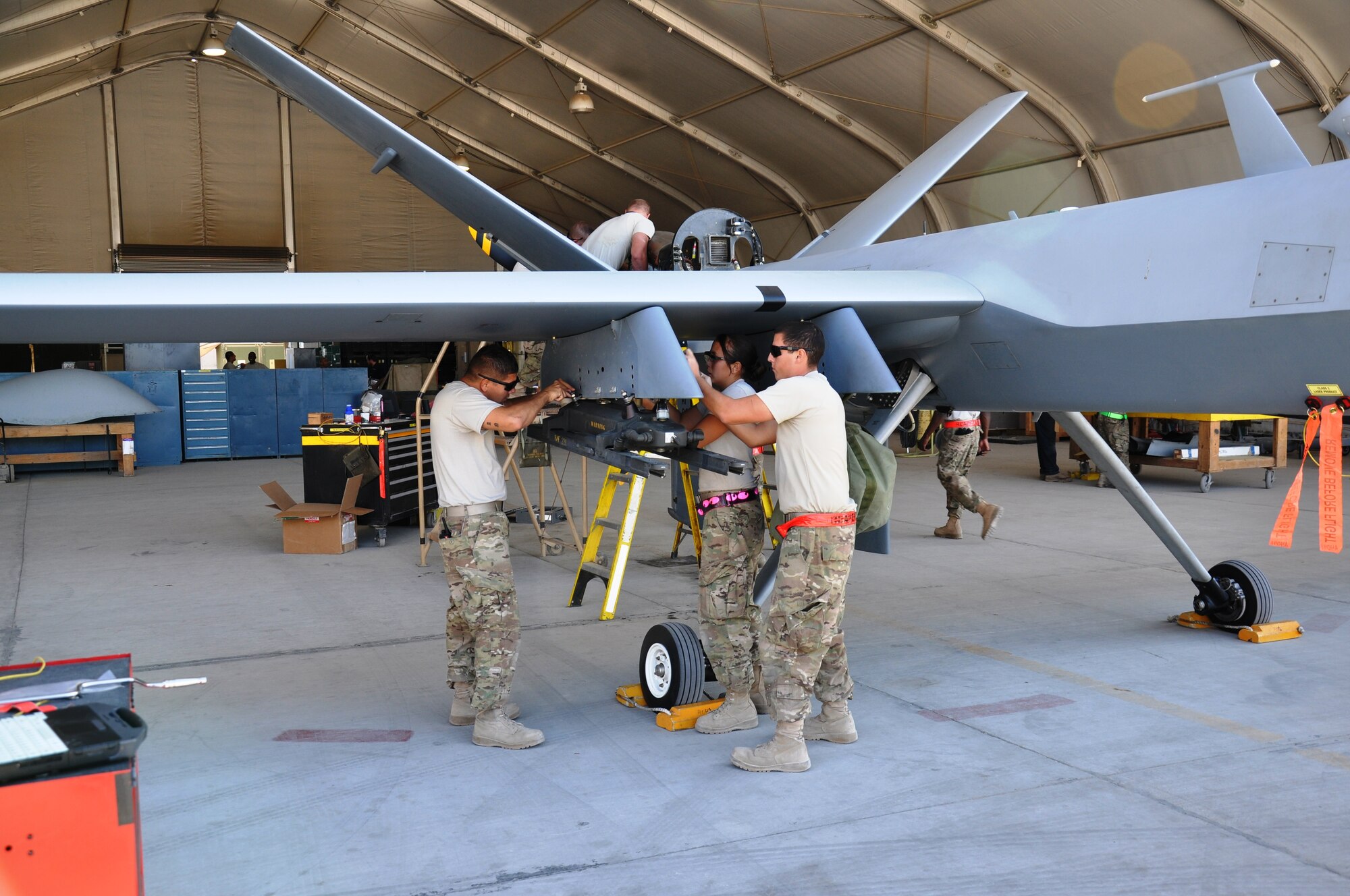 Tech. Sgt. Bobby Domanski, Staff Sgt. Alejandra Uribe and Airman First Class Dustin Robinson, weapons troops with the MQ-9 Aircraft Maintenance Unit, 451st Expeditionary Aircraft Maintenance Squadron, perform maintenance on station pylons on Nov. 3, 2012. (U.S. Air Force photo/Capt. Tristan Hinderliter) 