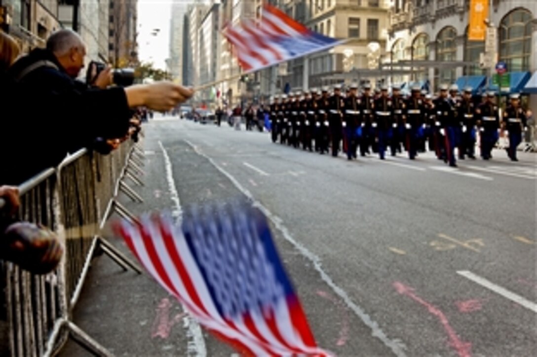 A New York crowd waves flags and cheers for Marines as they marched in the annual Veterans Day parade in New York, Nov. 11, 2012. Since Nov. 11, 1919, the parade has provided an opportunity for Americans and international visitors in the nation's largest city to honor those who have served. The Marines are assigned to the 6th Communications Battalion, Marine Forces Reserve.