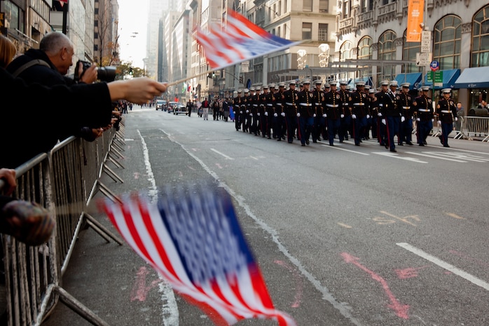 NEW YORK -- New Yorkers wave flags and cheer for Marines from 6th Communications Battalion, Marine Forces Reserve, as they marched in the annual New York Veterans Day parade, here, Nov. 11.  The parade is hosted by the United War Veterans Council, Inc. on behalf of the City of New York. It is the oldest and largest of its kind in the nation. Since November 11, 1919, the parade has provided an opportunity for Americans and International visitors to honor those who have served in the nation’s largest city. (Official Marine Corps photo by Cpl. Bryan Nygaard)
