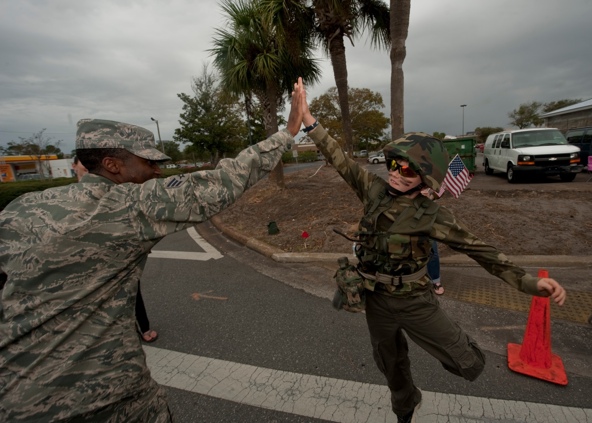 United States Air Force Senior Airman Derrick Raley Jr., fitness specialist of 1st Special Operations Force Support squadron, high-fives a child at the Veteran's Day Parade at the Santa Rosa mall in Mary Esther, Fla., Nov. 12, 2012. Military members participated in the Veteran's Day Parade to honor veterans of the present and past. (U.S. Air Force photo / Airman 1st Class Nigel Sandridge)