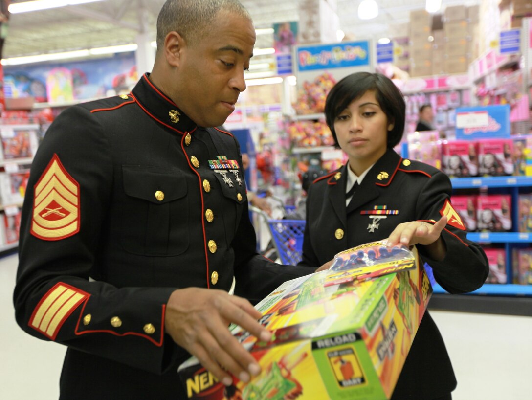 Gunnery Sgt. Jimmy Cosby Jr., the pay deck staff non-commissioned officer for the Marine Forces Reserve disbursing office, and Cpl. Cristel Zimmermanoset, zeros clerk at the finance office, MarForRes, decide on which toy to purchase for the Toys for Tots campaign. The Toys for Tots campaigns around the country have been helping give toys to less fortunate children since 1947. Marine Forces Reserve along with local community organizations are working hand-in-hand to top last years number of more than nine million toys, and continue their positive impact on the development of today's youth.
