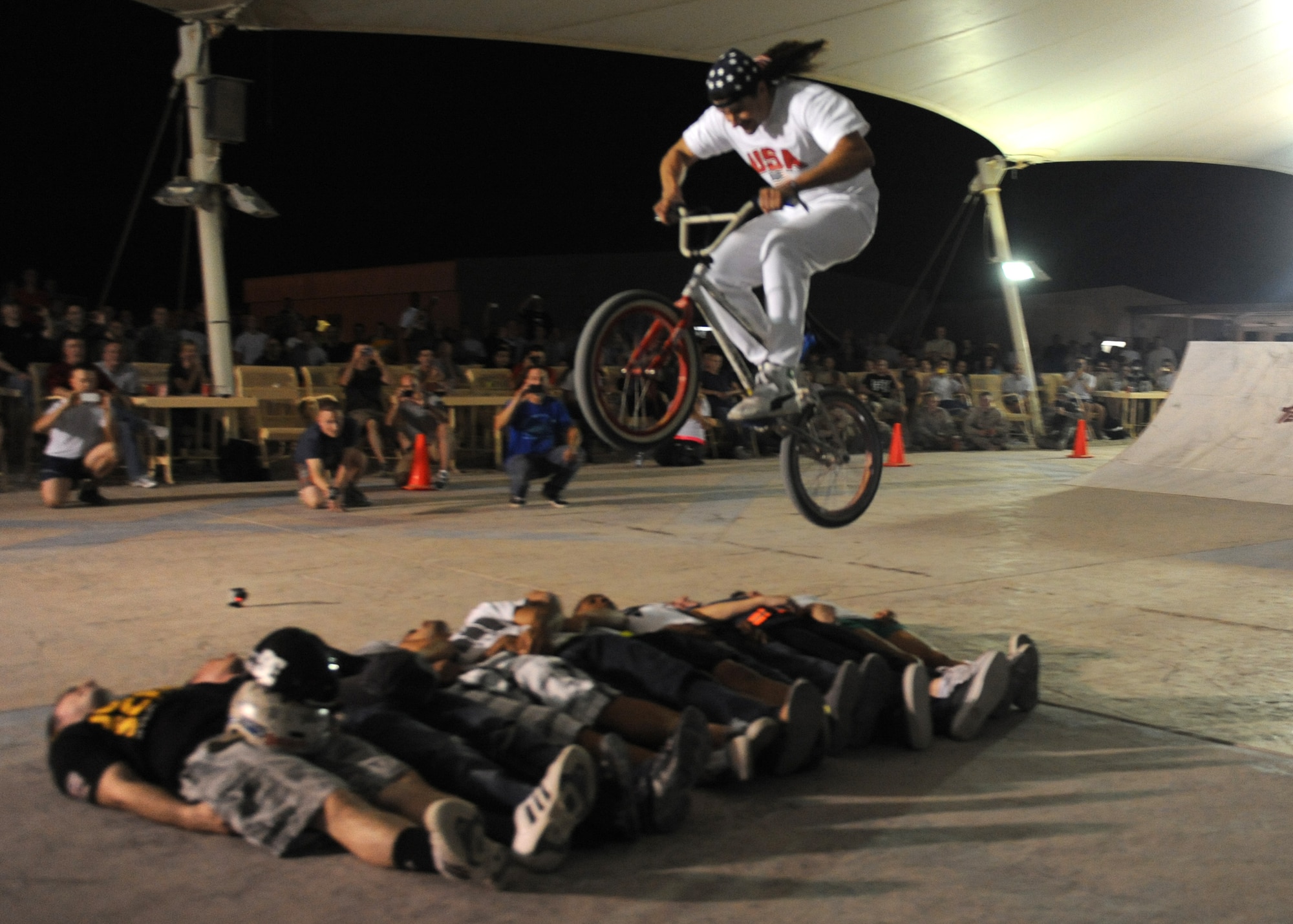SOUTHWEST ASIA – Bikes over Baghdad announcer, Darryl Nau, successfully jumps over eight service members during a performance for U.S. Armed Forces and Coalition members Nov. 11, 2012. This was the first stop of their tour across the area of responsibility. (U.S. Air Force/Senior Airman Joel Mease)