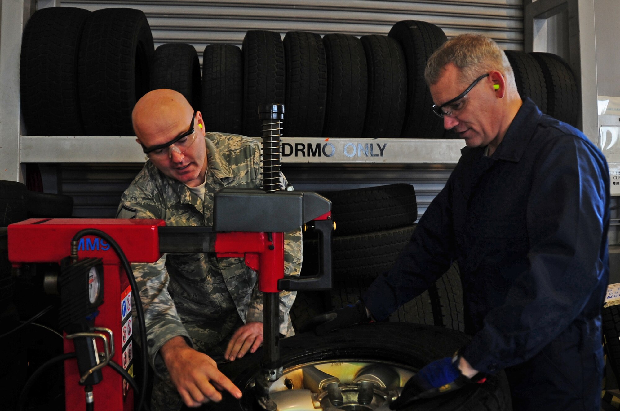 U.S. Air Force Master Sgt. Michael Poole, 35th Logistics Readiness Squadron vehicle management superintendent, assists Chief Master Sgt. James Laurent, 35th Fighter Wing command chief, with changing tires to get government vehicles ready for the winter season at Misawa Air Base, Japan, Nov. 13, 2012.  The Dirty Job program was initiated by Chief Laurent to allow the Airmen doing these jobs daily a chance to shine and be noticed by wing leadership.