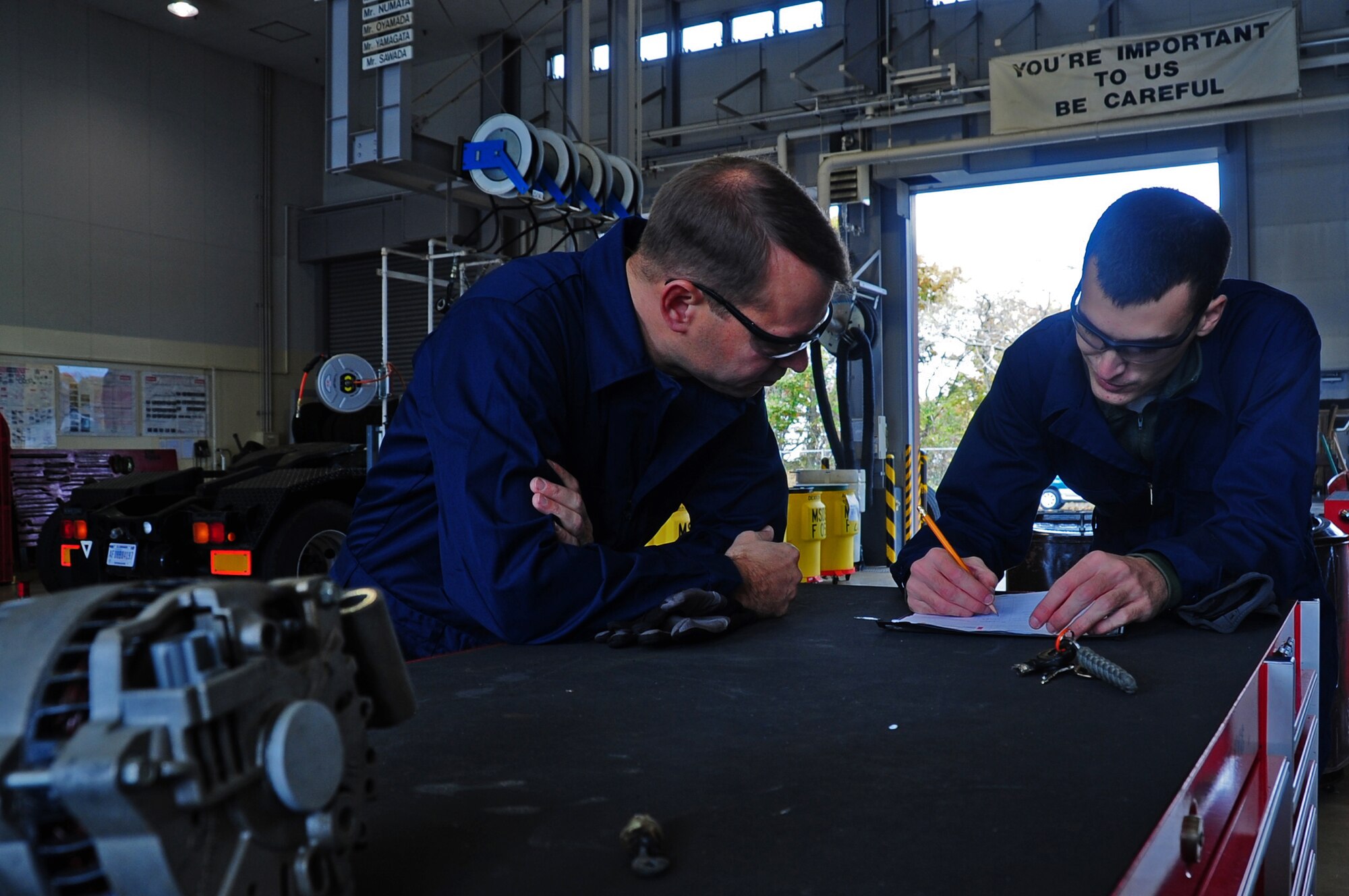 U.S. Air Force Airman 1st Class Alan Wilkins, 35th Logistics Readiness Squadron vehicle management journeymen, fills out a vehicle work order form after replacing an alternator on a vehicle with the assistance of Col. Stephen Williams, 35th Fighter Wing commander, as part of the dirty job program at Misawa Air Base, Japan, Nov. 13, 2012.  The Dirty Job program was initiated by Chief Laurent to allow Airmen the opportunity to show base leadership the work they do daily.