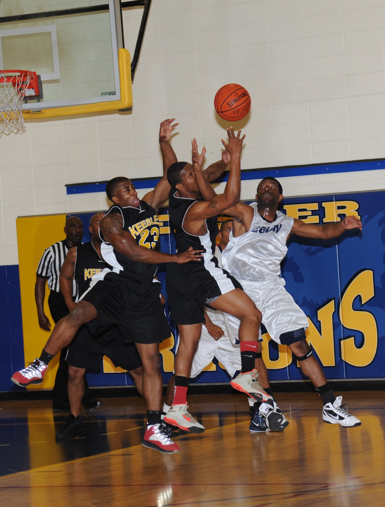 Justin Gachett and  John Moore, Keesler, and Stanton Simmons, Eglin Air Force Base, Fla., battle for a rebound ball during a varsity basketball game Nov. 10, 2012, at the Blake Fitness Center, Keesler Air Force Base, Miss.  Keesler defeated Eglin, 80-71.  The women’s varsity team also defeated Eglin, 83-48.  (U.S. Air Force photo by Kemberly Groue)