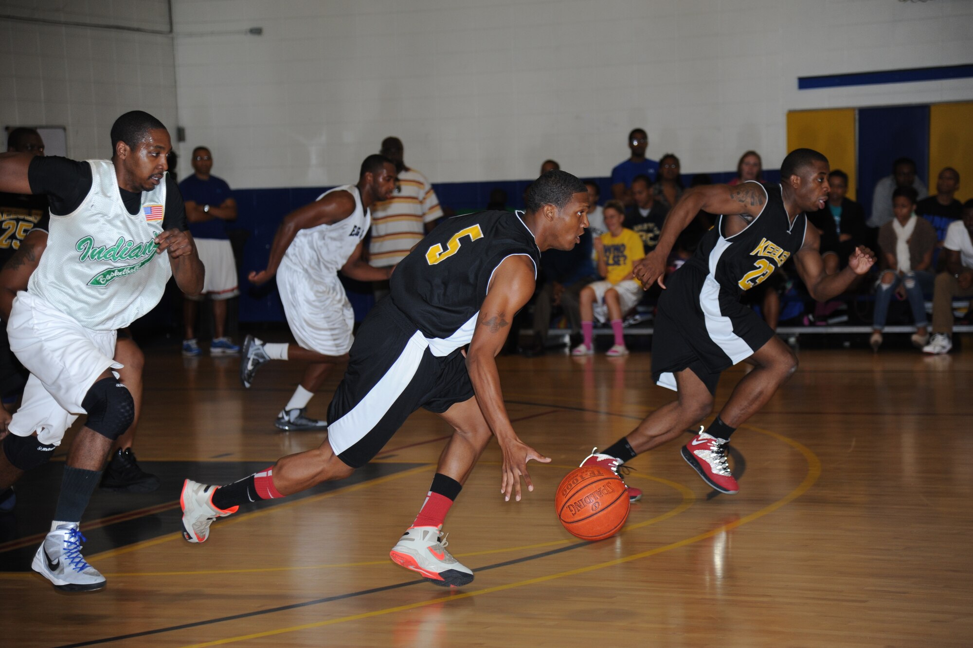 John Moore, Keesler,  drives the ball down the court as his teammate, Justin Gachett, runs long side of him and David Cason, Eglin Air Force Base, Fla., tails him during a varsity basketball game Nov. 10, 2012, at the Blake Fitness Center, Keesler Air Force Base, Miss.  Keesler defeated Eglin, 80-71.  The women’s varsity team also defeated Eglin, 83-48.  (U.S. Air Force photo by Kemberly Groue)