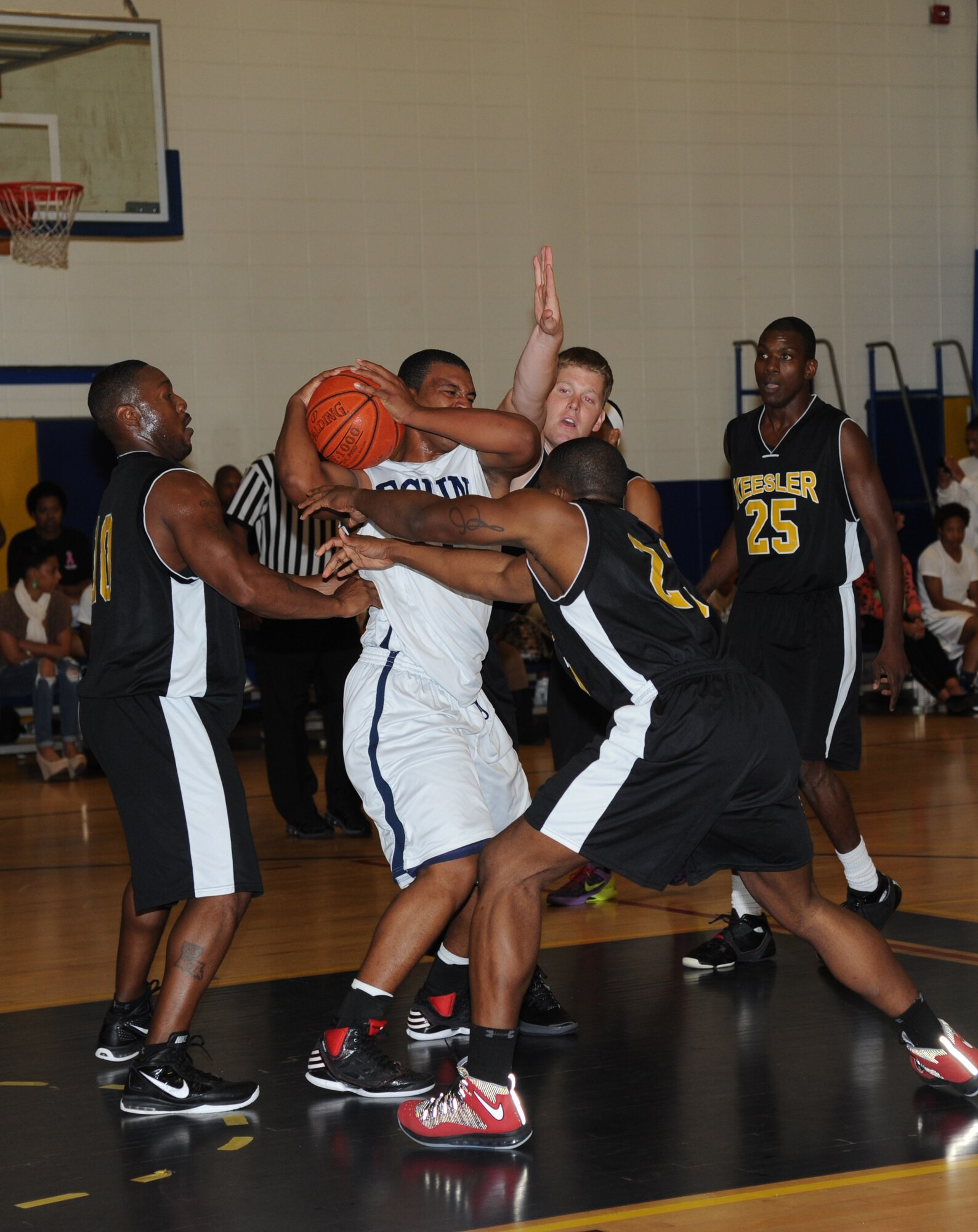 Dion Baynard, Eglin Air Force Base, Fla., is surrounded by members of Keesler during a varsity basketball game Nov. 10, 2012, at the Blake Fitness Center, Keesler Air Force Base, Miss.  Keesler defeated Eglin, 80-71.  The women’s varsity team also defeated Eglin, 83-48.  (U.S. Air Force photo by Kemberly Groue)