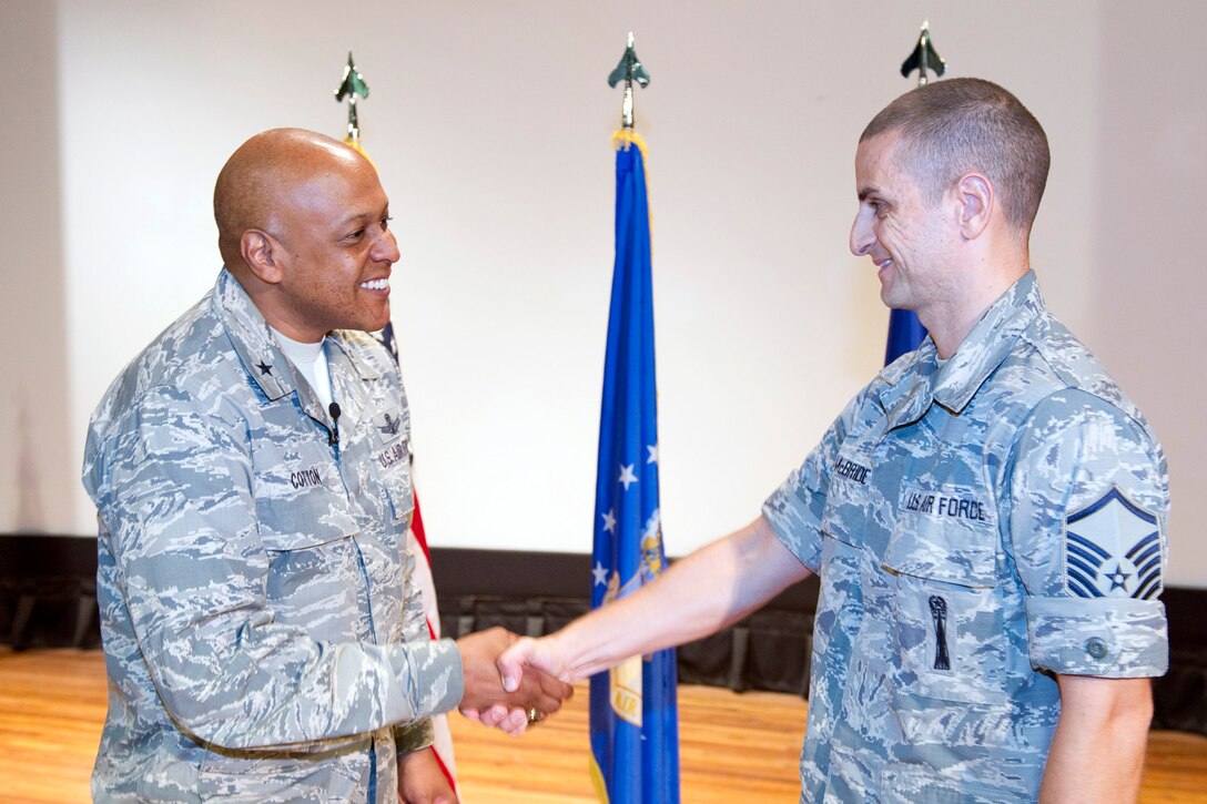 Brig. Gen. Anthony Cotton, commander, 45th Space Wing, coins Master Sgt. Marshall McBride, 5th Launch Support Squadron, for his hard work and completion of the Air Force Senior NCO Academy as a distinguished graduate. 