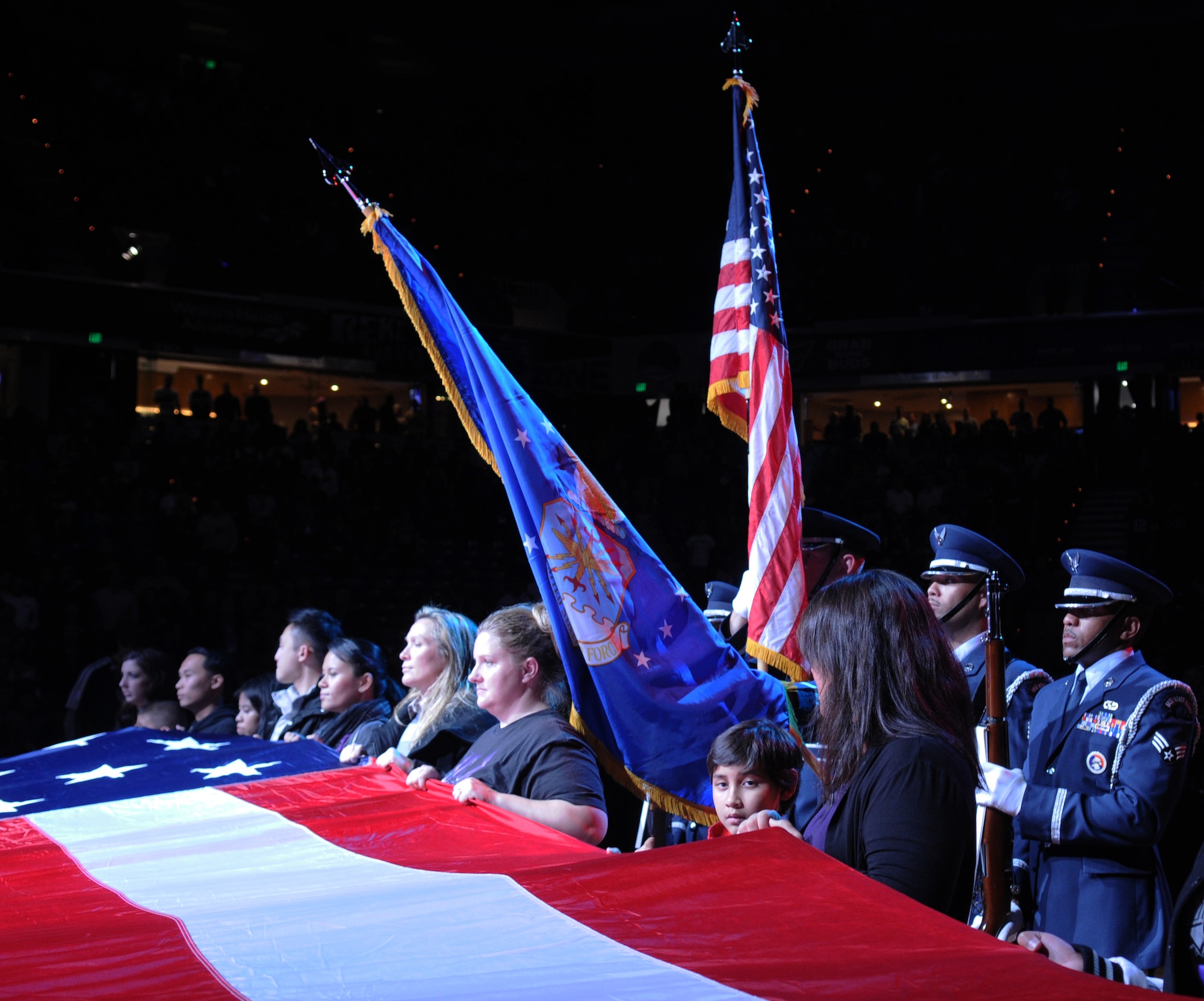 Servicemembers, veterans and volunteers hold the American flag while the Beale Air Force base color guard presents the colors during the opening ceremonies at a Sacramento Kings game in Sacramento, Calif., Nov. 9, 2012. The Kings held a military appreciation night in honor of Veterans Day. (U.S. Air Force photo by Airman 1st Class Stephanie Lovito/Released)