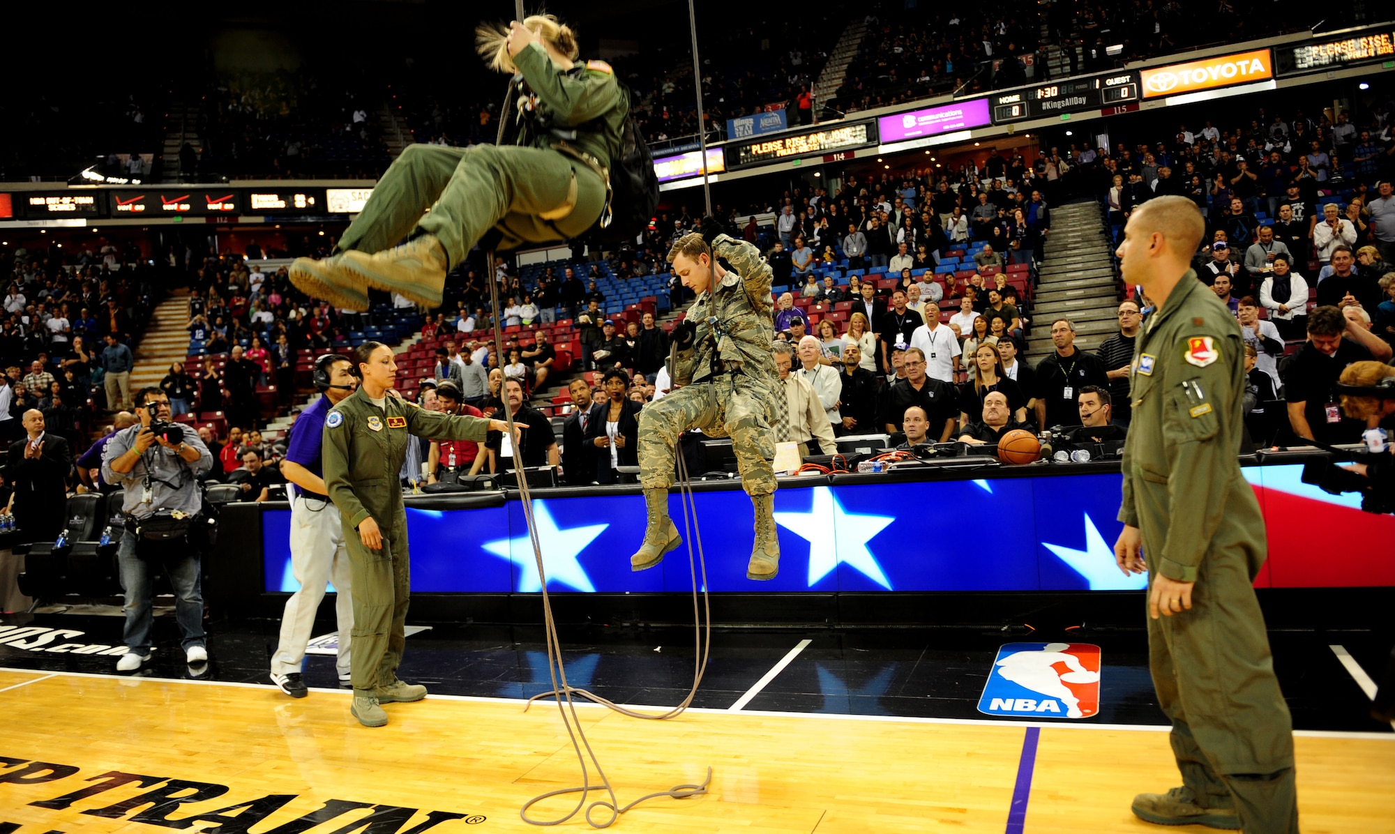 Airmen from Travis Air Force Base rappel to the floor of Sleep Train Arena during a Sacramento Kings game versus the San Antonio Spurs in Sacramento, Calif., Nov. 9, 2012. The Airmen presented the players with the game ball. (U.S. Air Force photo by Senior Airman Shawn Nickel/Released)