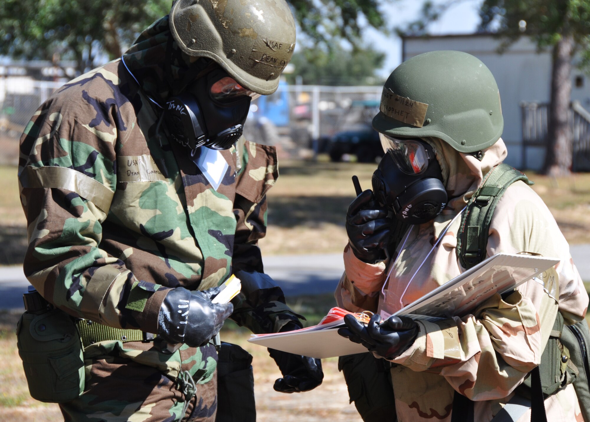 Senior Airman Dean Carmichael, left, and Master Sgt. Tiffany Prophet of the 919th Special Operations Wing staff relay post-attack information during a recent chemical warfare exercise at Duke Field, Fla.   The exercise helped the Air Force reservists hone their combat readiness skills for worldwide deployment. (U.S. Air Force photo/Dan Neely)