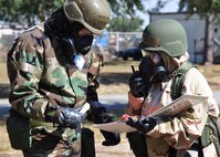 Senior Airman Dean Carmichael, left, and Master Sgt. Tiffany Prophet of the 919th Special Operations Wing staff relay post-attack information during a recent chemical warfare exercise at Duke Field, Fla.   The exercise helped the Air Force reservists hone their combat readiness skills for worldwide deployment. (U.S. Air Force photo/Dan Neely)