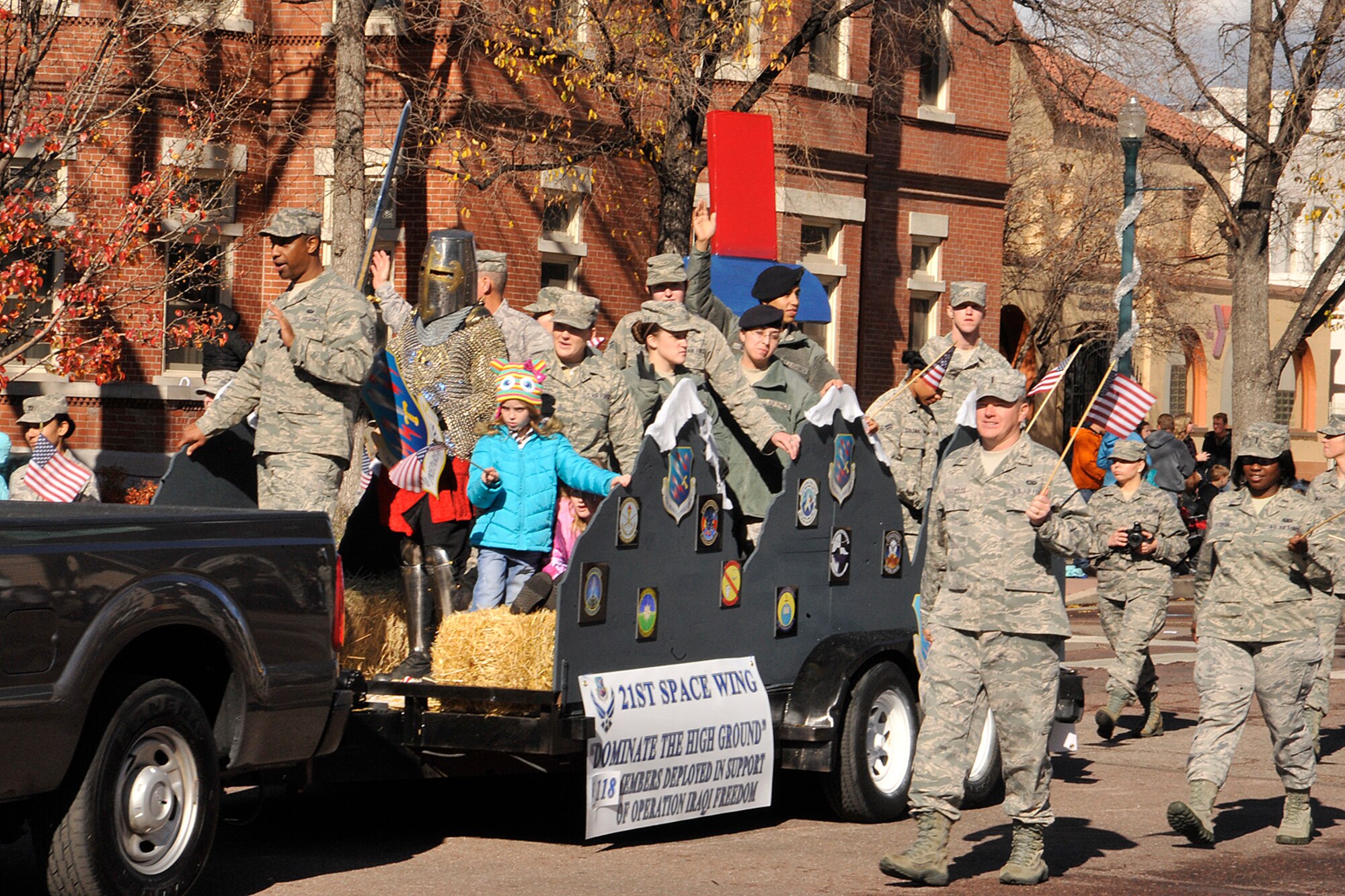 COLORADO SPRINGS, Colo. -- Airmen and family members from the 21st SW Airmen ride and march beside the 21st SW float in the Veterans Day Parade Nov. 10 in Colorado Springs. The parade, one of the biggest in the United States, draws more than 100 entries and tens of thousands of spectators each year. (U.S. Air Force photo/Dennis Howk)