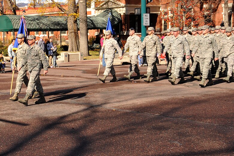 COLORADO SPRINGS, Colo. -- Col. Chris Crawford, 21st Space Wing commander, and Chief Master Sgt. Richard Redman, 21st SW command chief, lead a flight of 21st SW Airmen during the Colorado Springs Veterans Day Parade Nov. 10 in downtown Colorado Springs. The parade, one of the biggest in the United States, draws more than 100 entries and tens of thousands of spectators each year. (U.S. Air Force photo/Dennis Howk)