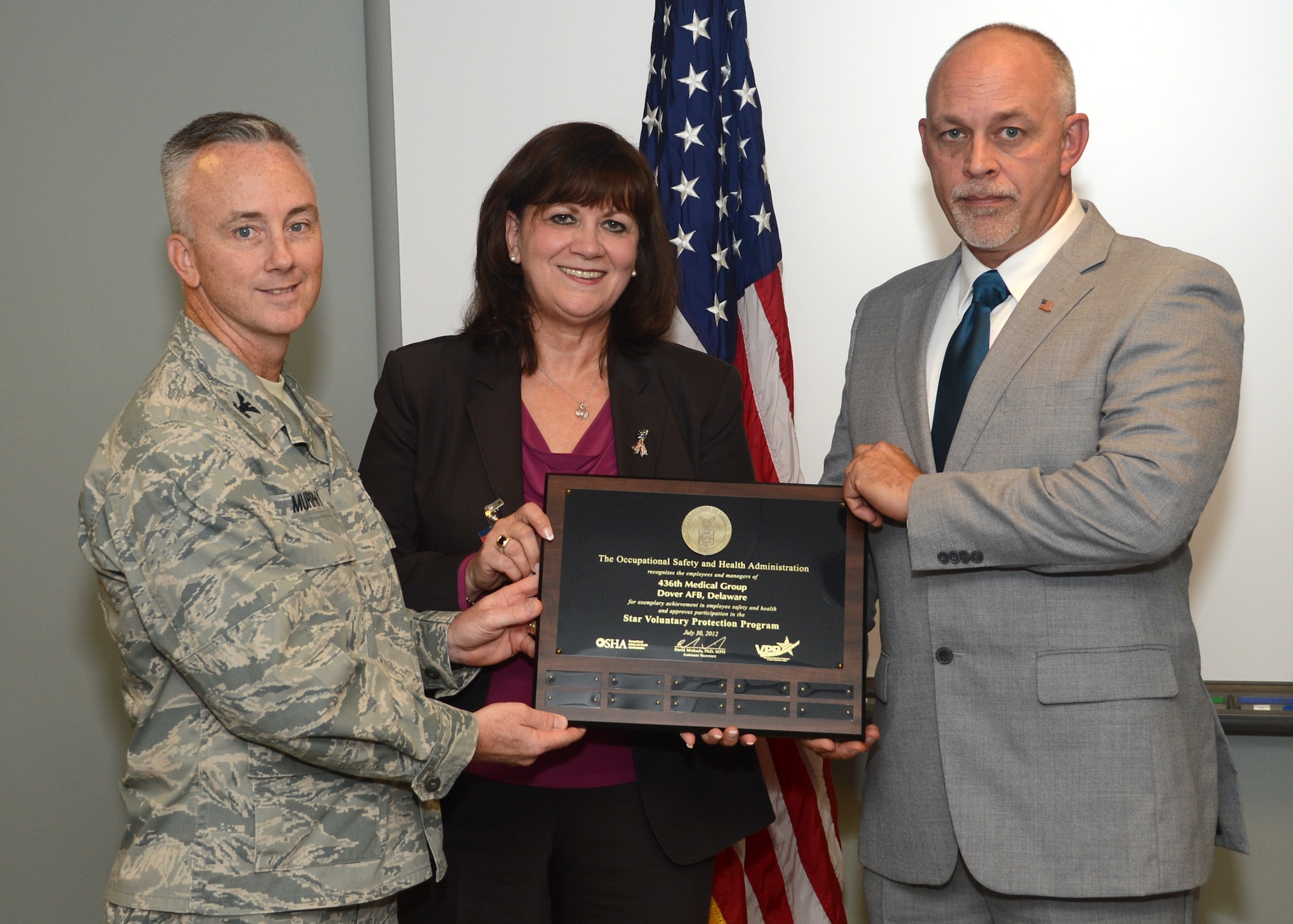 Col. Kevin Murphy, 436th Medical Group commander, Teresa Penn, Occupational Safety & Health Administration region 3 administrator, and Jerry Davies, union president of American Federation of Government Employees 1709, pose with the Voluntary Protection Program Award Nov. 7, 2012, at the 436th MDG clinic on Dover Air Force Base, Del. The 436th MDG was one of approximately 2,255 businesses nationwide that received Star Status for its safety program. (U.S. Air Force photo by Tech. Sgt. Chuck Walker) 