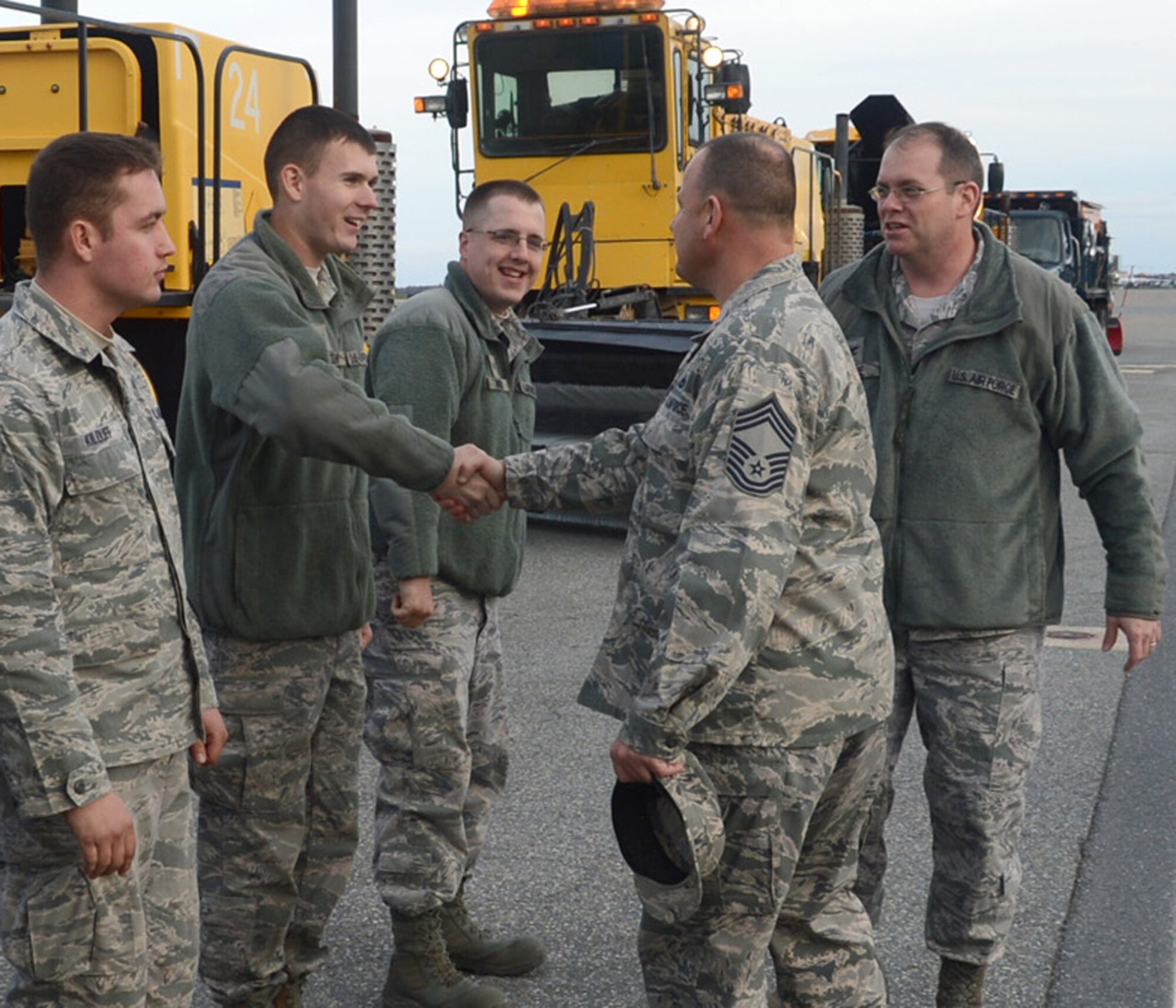 Chief Master Sgt. James Smith, 436th Airlift Wing command chief, shakes hands with Airmen from the 436th Civil Engineer Squadron Nov. 6, 2012, at Dover Air Force Base, Del. Col. Moore and the chief took part in the annual Snow Parade, in which they drove 436th CES snow removal vehicles on the flightline. (U.S. Air Force photo by Tech. Sgt. Chuck Walker)