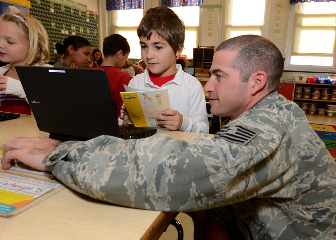 Tech. Sgt. Michael Schroeder, 436th Maintenance Squadron, helps his son Sean navigate on a computer Nov. 9, 2012, at Lake Forest North Elementary School in Felton, Del. Team Dover members spoke to students about their jobs and the military as part of a Veteran’s Day celebration hosted by the school. (U.S. Air Force photo by Tech. Sgt. Chuck Walker)
