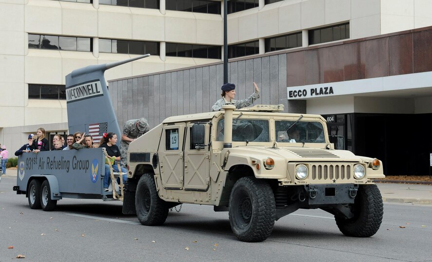 Capt. Patrice Reviere, 22nd Aerospace Medicine Squadron bioenvironmental engineering flight commander, distributes beads to the crowd during Wichita’s Veterans Day Parade Nov. 10, 2012, Wichita Kan. Reviere attended the parade with other Airmen from McConnell to honor those who have served in the U.S. armed forces. (U.S. Air Force photo/2nd Lt. Jessica Brown)
