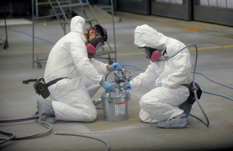 U.S. Air Force Staff Sgt. Jamey Jackson and Airman 1st Class Paul Kumagai, 23d Equipment Maintenance Squadron aircraft structural maintainers, attach spray nozzles on the paint can at Moody Air Force Base, Ga., Nov. 7, 2012. The fabrication flight applied two coats of paint on an A-10C Thunderbolt II to ensure accurate coverage. (U.S. Air Force photo by Airman 1st Class Olivia Bumpers/Released)