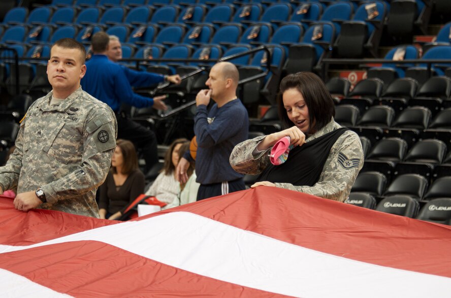 MINNEAPOLIS, Minn. -Staff Sgt. Samantha Malenke, a bio environmental engineer with the 133rd Airlift Wing, tends to her newborn baby while practicing for flag detail at the Minn. TImberwolves' Military Appreciation Night Nov. 9 at the Target Center. (U.S. Aif Force photo by Staff Sgt. Jonathan Young.)