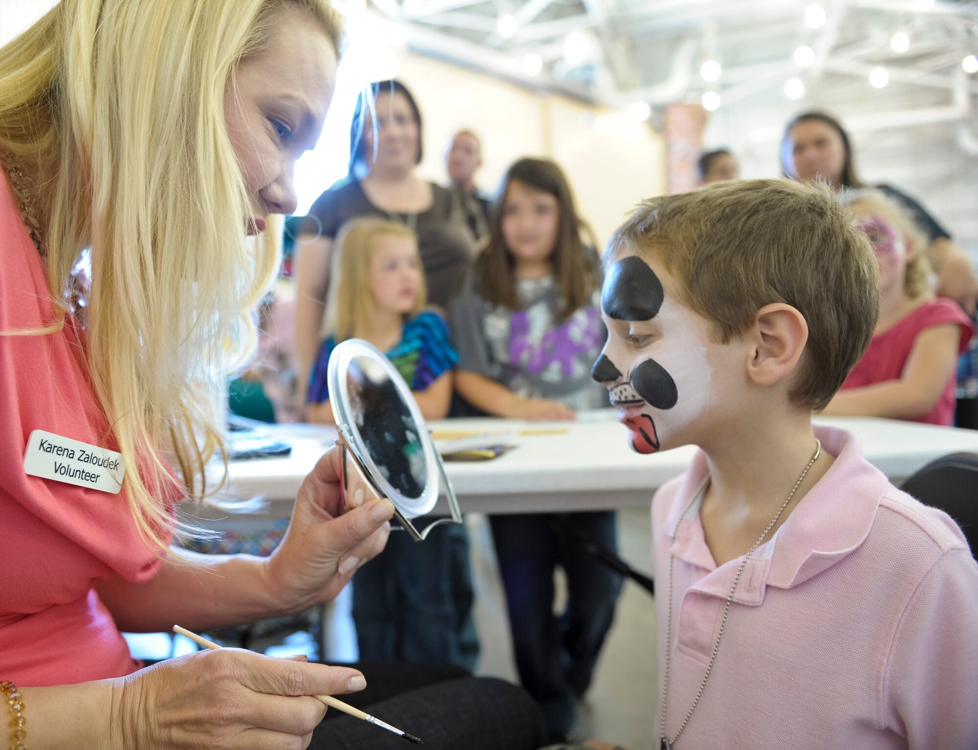 Maj. Kerena Zaloudek, 330th Combat Training Squadron, shows Avery Register a puppy dog she painted on his face during the 116th and 461st Air Control wings annual Family Day celebration at Robins Air Force Base, Ga., Nov. 3, 2012. This marked the 10th annual Family Day for JSTARS.  The yearly event provides an opportunity to thank families for their support.   (National Guard photo by Master Sgt. Roger Parsons/Released)