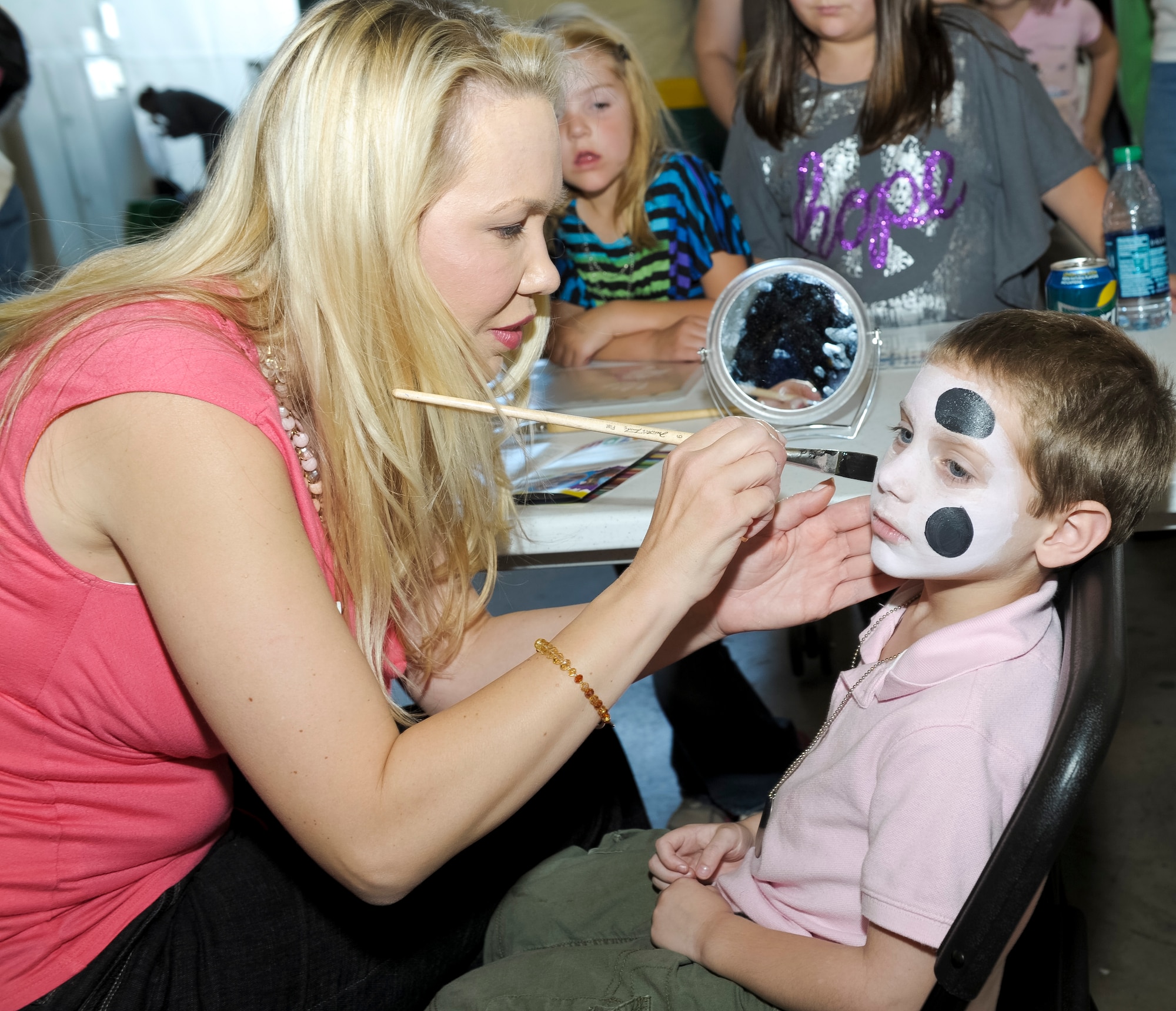 Maj. Kerena Zaloudek, 330th Combat Training Squadron, paints a puppy dog on the face of Avery Register during the 116th and 461st Air Control wings annual Family Day celebration at Robins Air Force Base, Ga., Nov. 3, 2012. This marked the 10th annual Family Day for JSTARS.  The yearly event provides an opportunity to thank families for their support.   (National Guard photo by Master Sgt. Roger Parsons/Released)