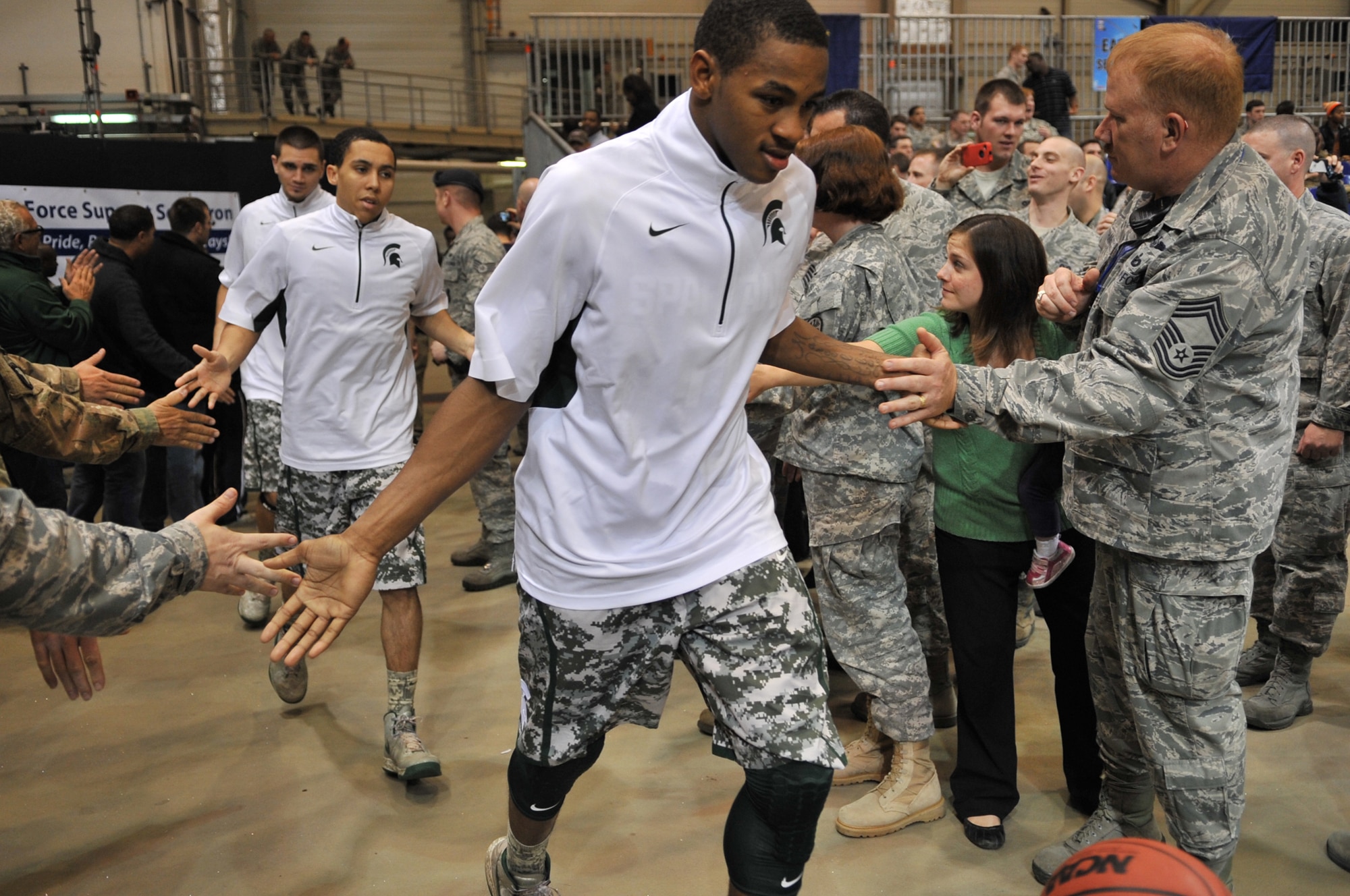 Michigan State Spartan players slap hands of service members after half time during the Armed Forces Classic basketball game between Michigan State Spartans and University of Connecticut Huskies at Ramstein Air Base, Germany, Nov. 10, 2012.  The Huskies overcame the Spartans 66-62. (U.S. Air Force photo/Master Sgt. Wayne Clark)