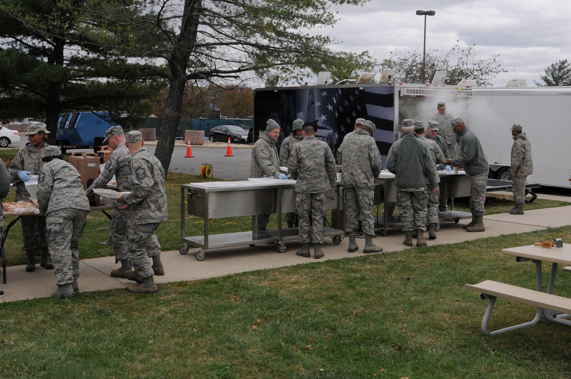 Airman from the 113th Wing wait in line to be fed during a new mobile field kitchen during a demonstration at Joint Base Andrews, Md., Nov. 3. The Disaster Relief Mobile Kitchen Trailer  can deploy to natural disaster sites to provide hot meals to relief workers and Airmen working in austere conditions. (U.S. Air force photo by Airman 1st Class Sumena Leslie/Released)