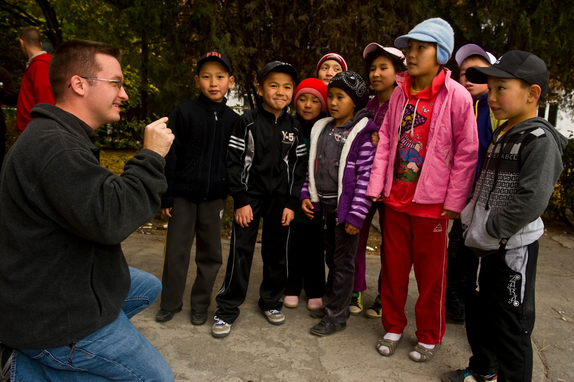 Senior Airman Brett Clashman communicates through sign language with the children at the Bishkek School for the Deaf during a recent visit. Clashman, 376th Air Expeditionary Wing Public Affairs photojournalist, was a frequent visitor during community outreach initiatives at the school, which accepts and boards hearing impaired children from across Kyrgyzstan. Clashman is a native of Deer Park, Ohio and deployed from Nellis Air Force Base, Nev. U.S.Air Force photo/Staff Sgt. Matt Benedetti) 