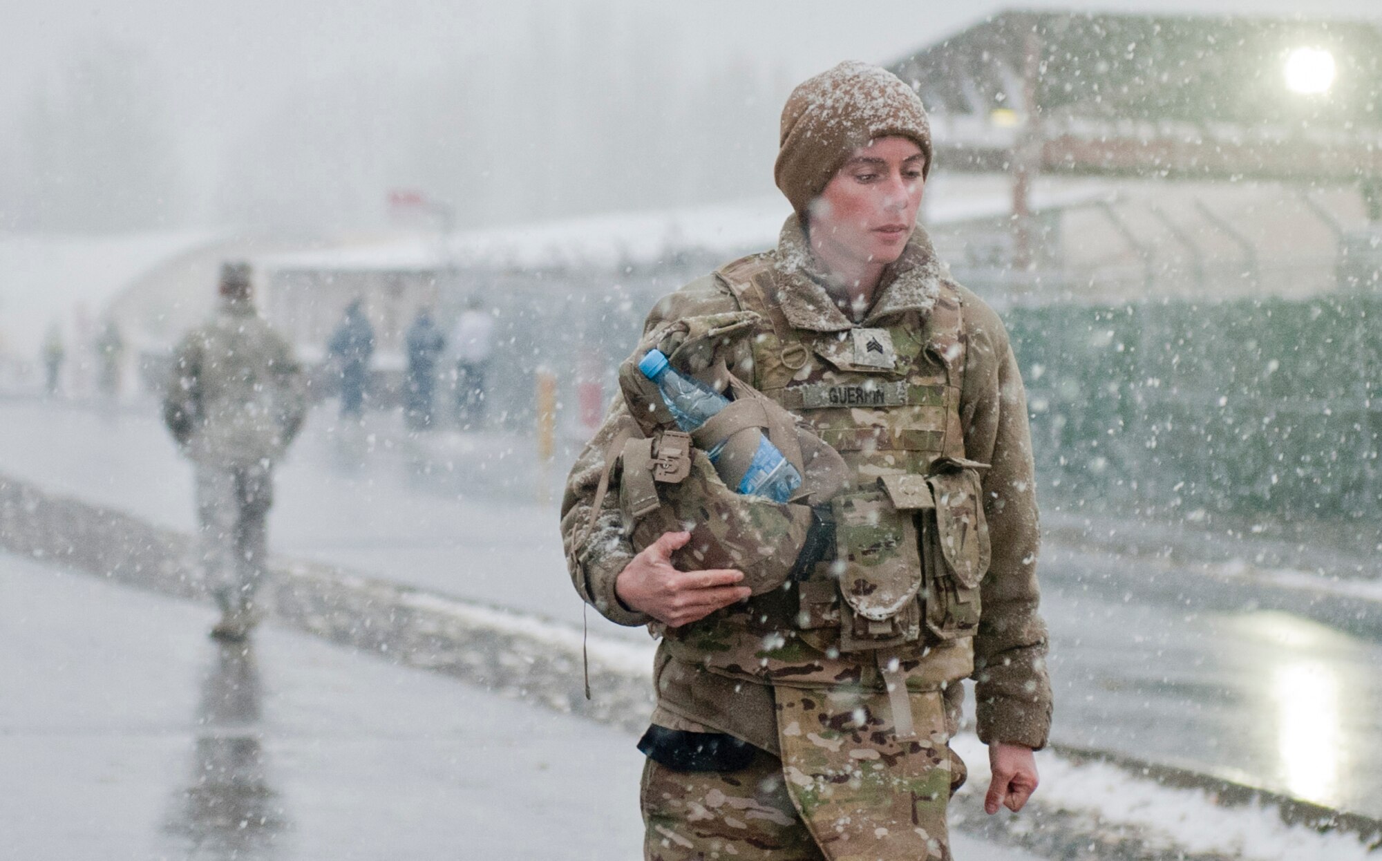 U.S. Army Sergeant Theresa Guerrin walks a populated road during the first snow fall of the season at the Transit Center at Manas, Kyrgyzstan, Nov. 12, 2012. Guerrin, who is passing through the Transit Center on her way to Afghanistan, is a 1048th Transportation Company recovery specialist deployed from Army National Guard Stratford Armory, Conn., and is a native of Stafford Springs, Conn. (U.S. Air Force photo / Senior Airman Stephanie Rubi)  