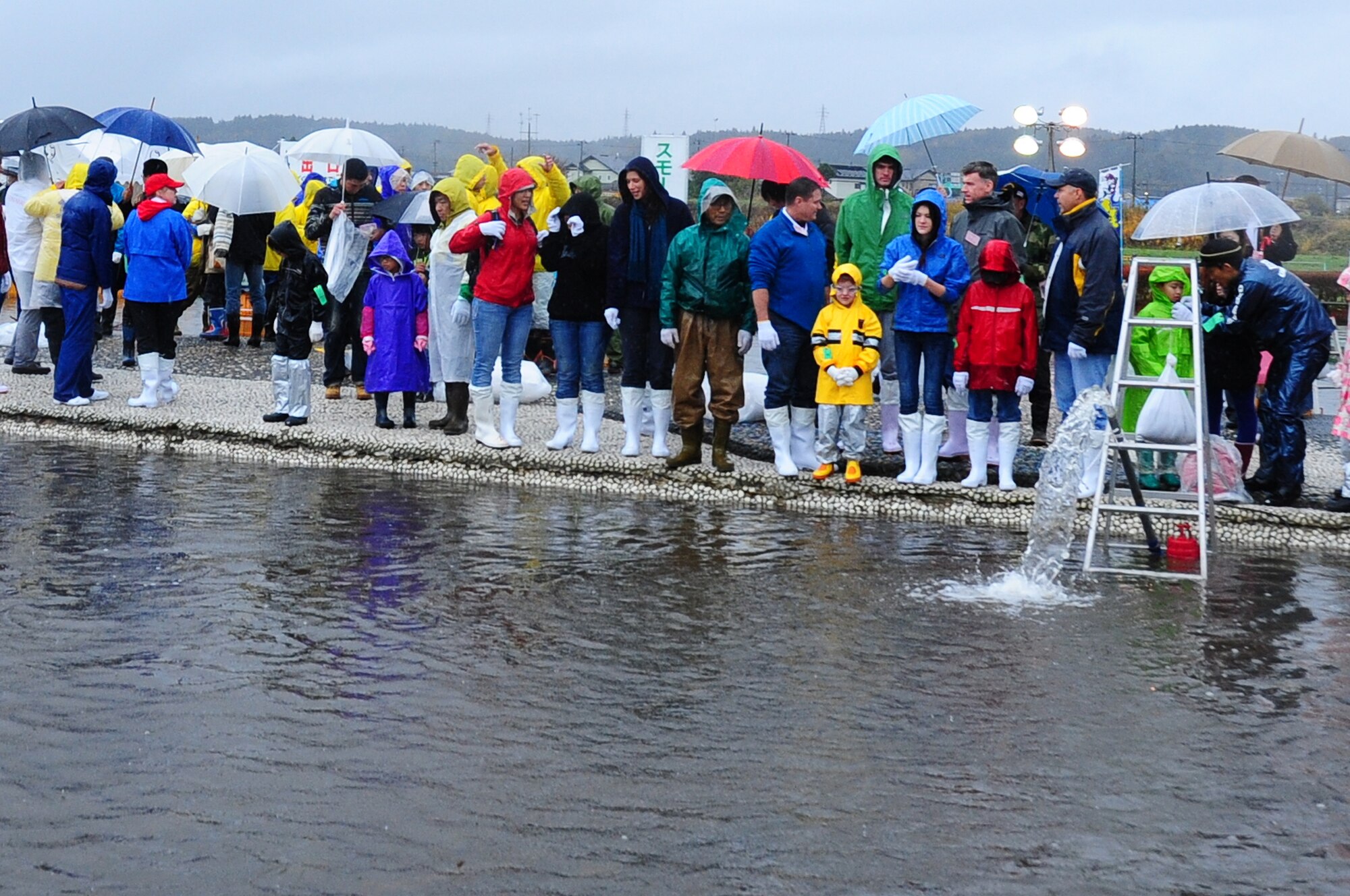 Fish catchers from Misawa Air Base, Japan and the local Japanese community wait on the edge of the wading pool at Salmon Park, Oirase, Japan during the annual Oirase Salmon Catching Festival, Nov. 10, 2012. Participants were given the opportunity to catch salmon with their hands and take them home. (U.S. Air Force photo/ Staff Sgt. April Quintanilla)